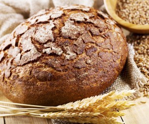 fresh bread with wheat ears on wooden table