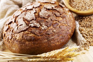 fresh bread with wheat ears on wooden table