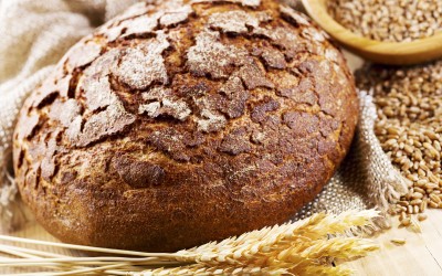 fresh bread with wheat ears on wooden table