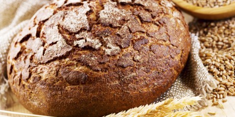 fresh bread with wheat ears on wooden table