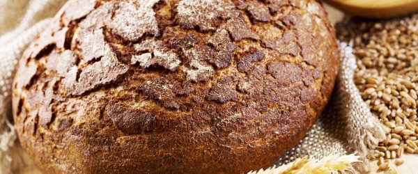 fresh bread with wheat ears on wooden table